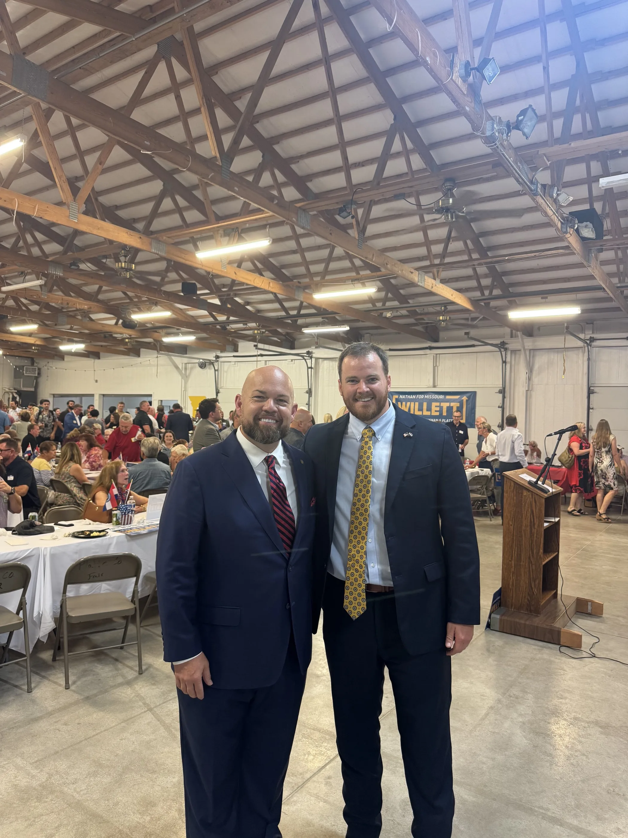 Nathan Willett and Chris Stigall together at Nathan's kickoff, Willett sign on the wall behind them